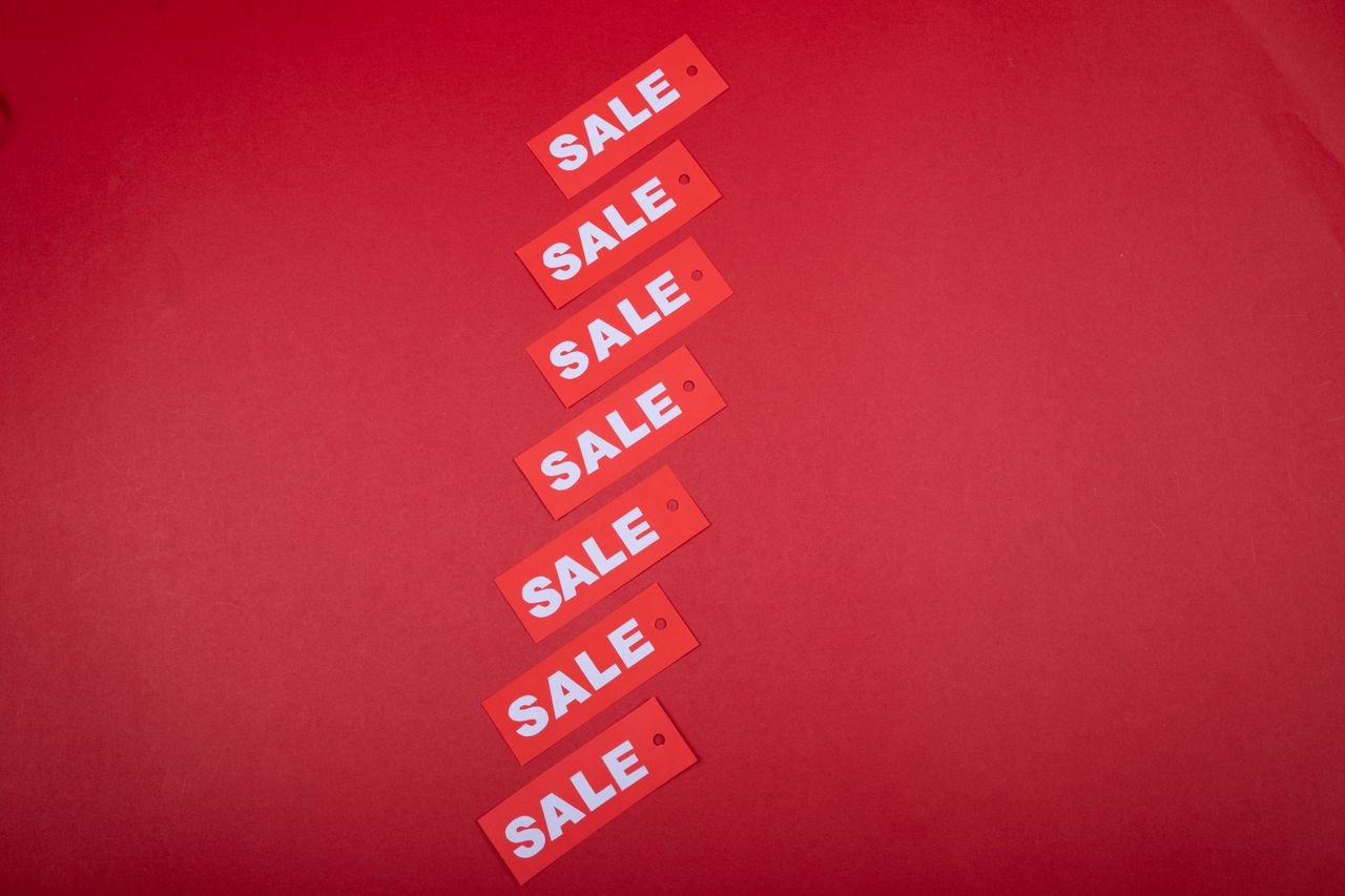 Crafting Captivating Headlines: Your awesome post title goes here Top view of red sale tags arranged on a vibrant red background for commercial use.